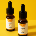 Two Vitamin C serum bottles with orange slice labels on a warm yellow surface in soft natural lighting, featured on rosvia.com.